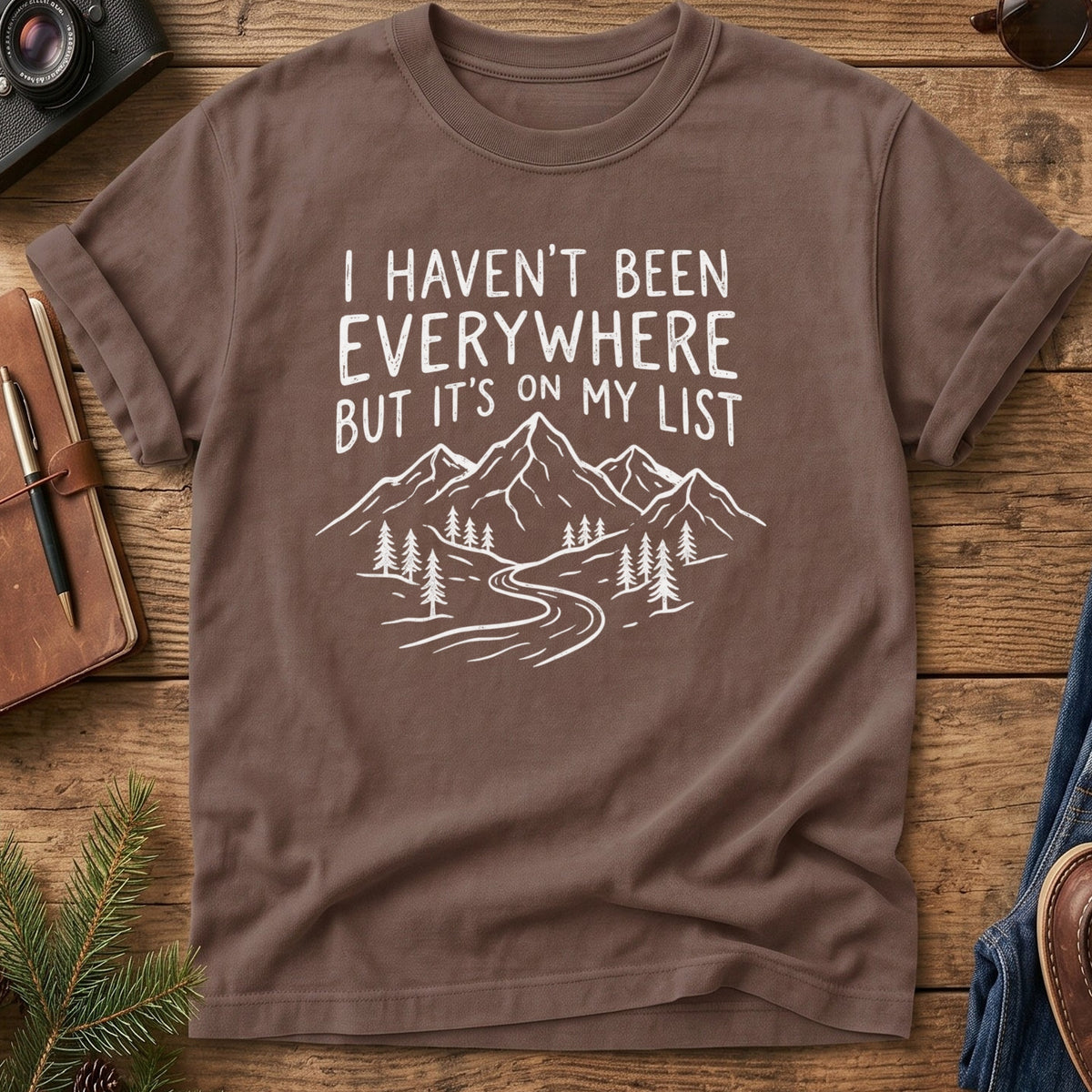 I Haven't Been Everywhere Tee in Espresso — mountain and river wanderlust graphic with hand lettering