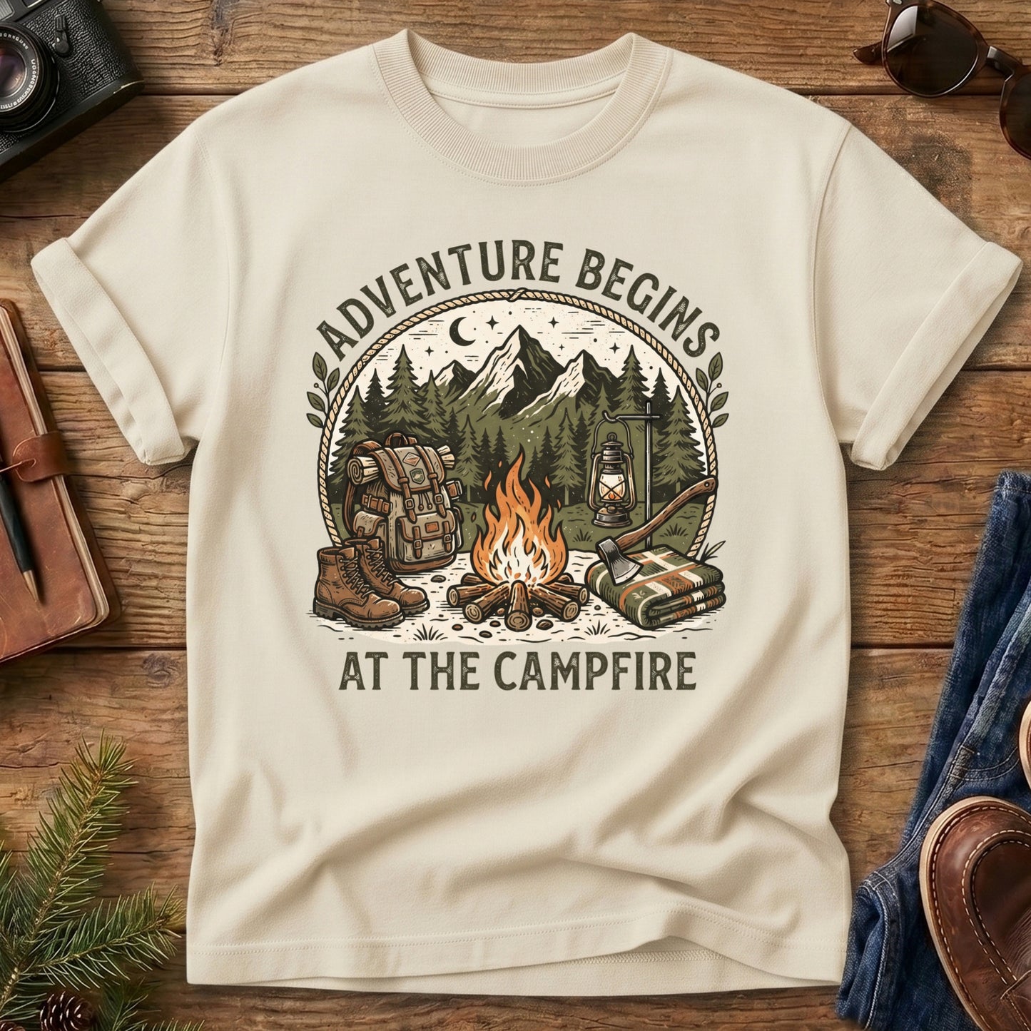 Adventure Begins Tee – styled flat lay, campfire badge graphic
