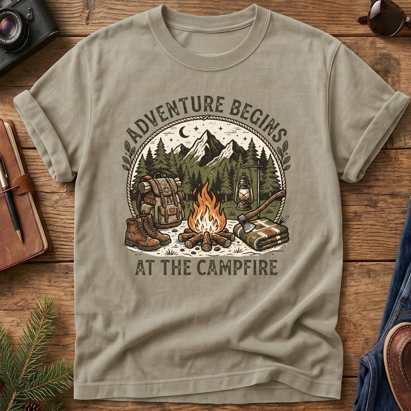 Adventure Begins Tee – styled flat lay, campfire badge graphic