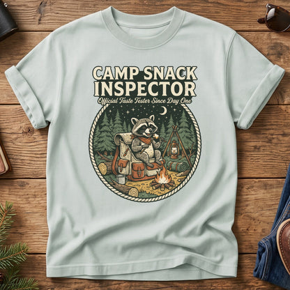 Camp Snack Inspector Tee – Bay flat lay, raccoon campfire graphic