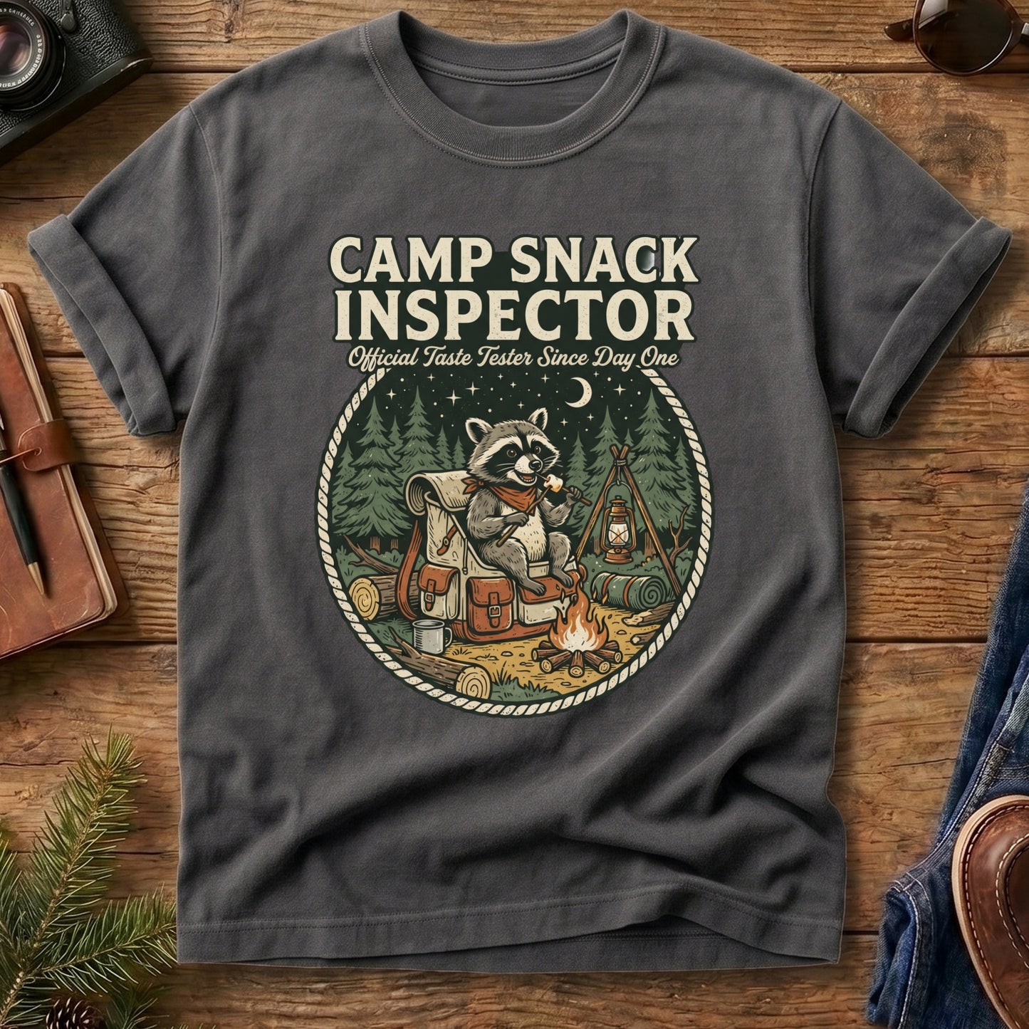 Camp Snack Inspector Tee – Grey flat lay, raccoon campfire graphic