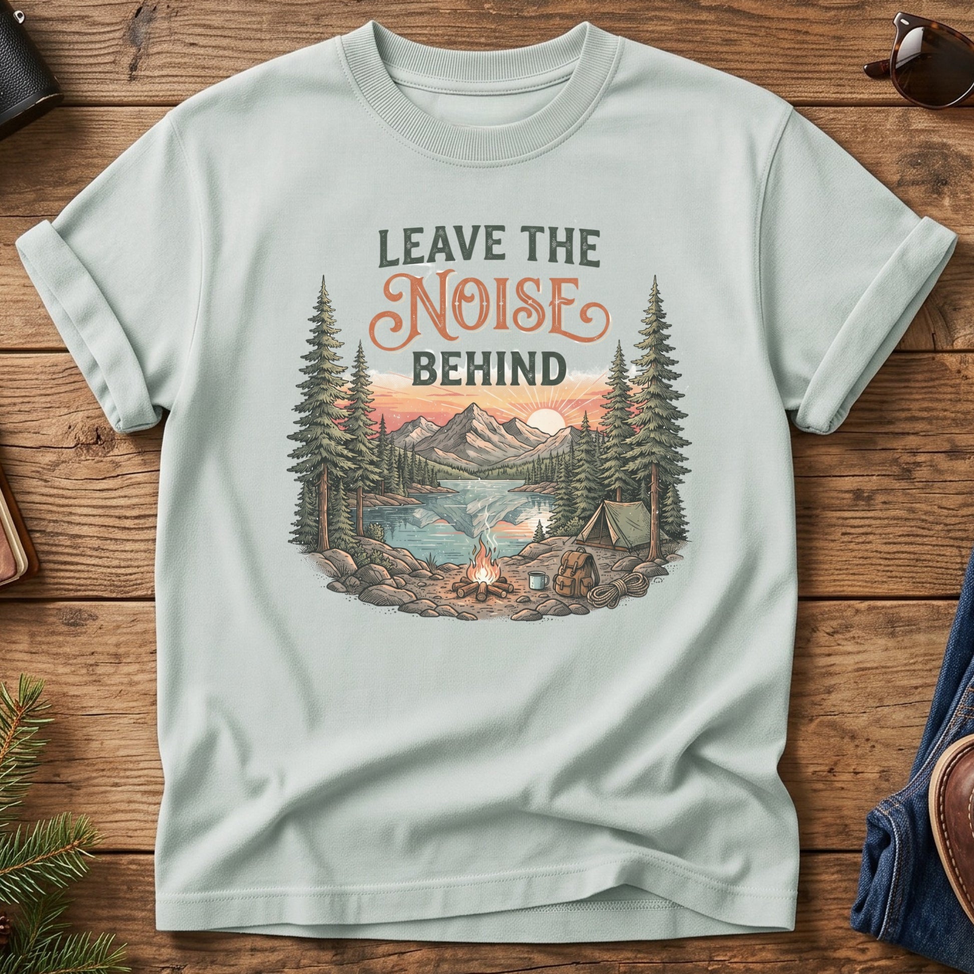 Leave the Noise Behind Tee – lakeside campsite with tent and campfire graphic on Comfort Colors 1717 tee, flat lay