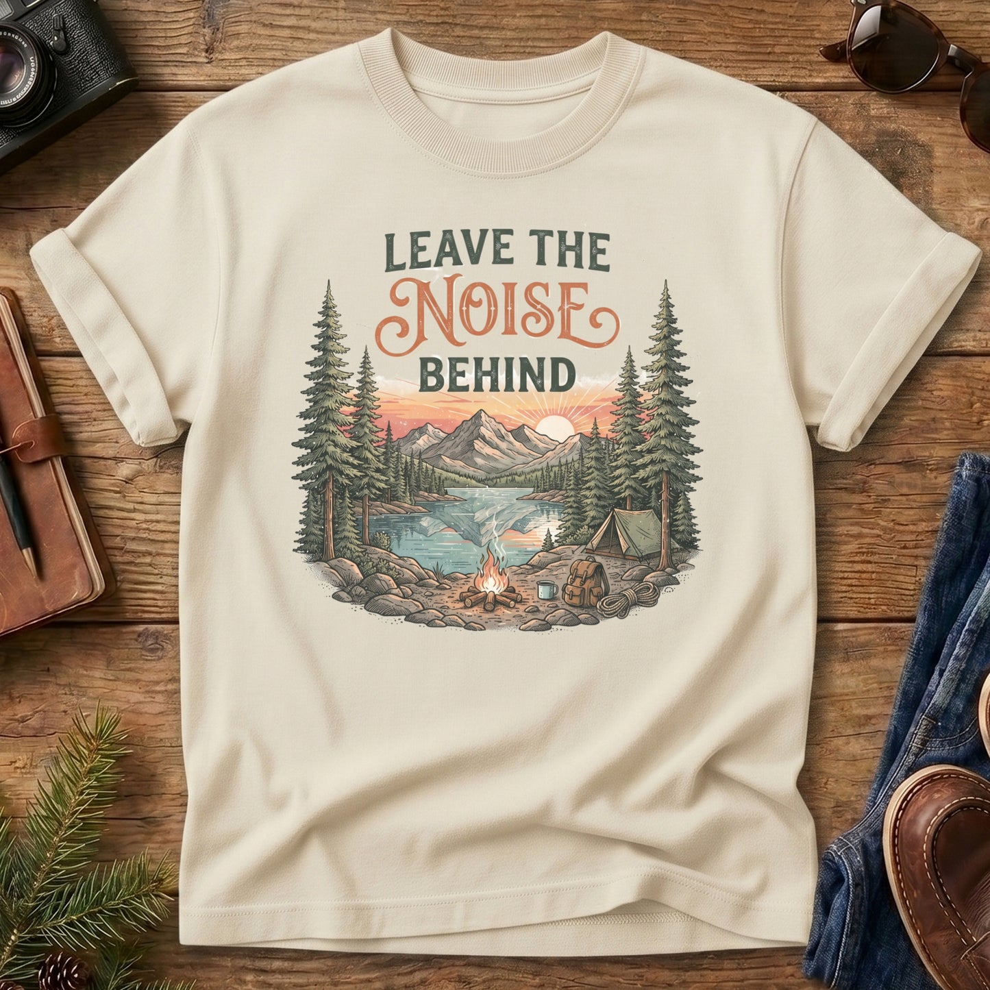 Leave the Noise Behind Tee – lakeside campsite with tent and campfire graphic on Comfort Colors 1717 tee, flat lay