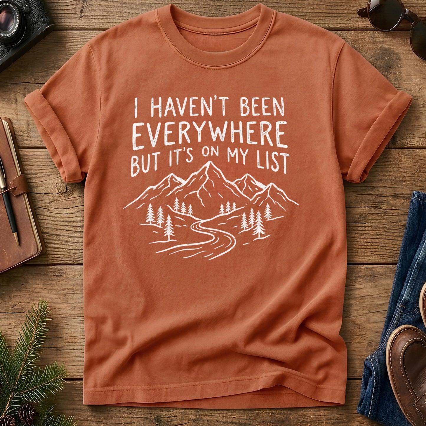 I Haven't Been Everywhere Tee in Yam — mountain and river wanderlust graphic with hand lettering