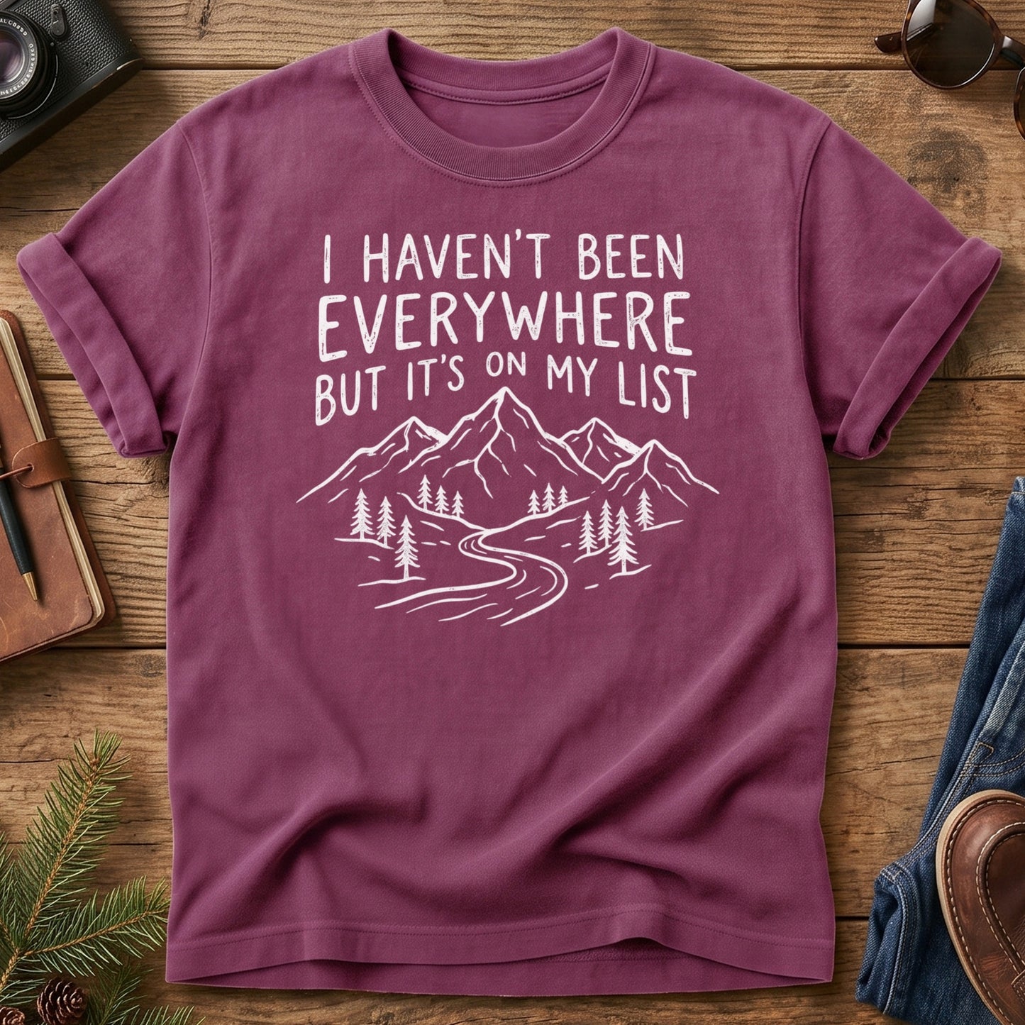 I Haven't Been Everywhere Tee in Berry — mountain and river wanderlust graphic with hand lettering