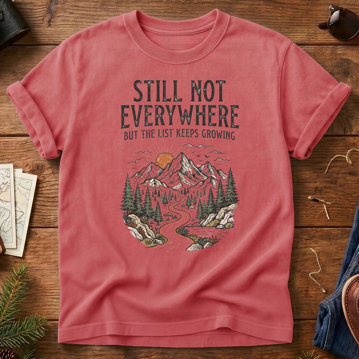 Still Not Everywhere Tee – mountain river valley sunrise graphic on Comfort Colors 1717 tee, flat lay
