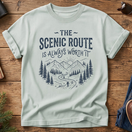 The Scenic Route Is Always Worth It Tee – hiker on winding mountain trail graphic on Comfort Colors 1717 tee, flat lay