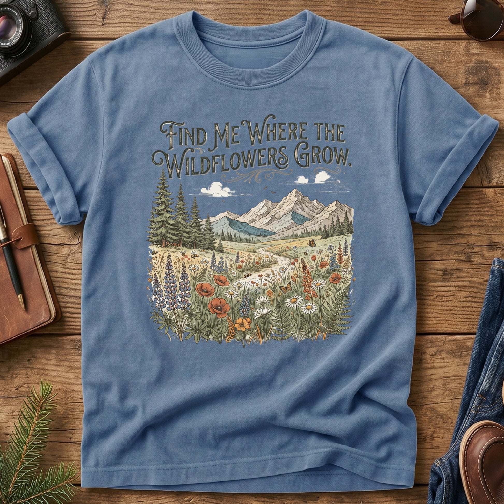 Wildflower Trail Tee – Blue Jean flat lay, wildflower meadow trail graphic with Find Me Where the Wildflowers Grow text